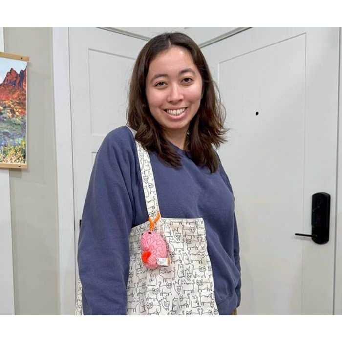 Brain key chain on bag with woman