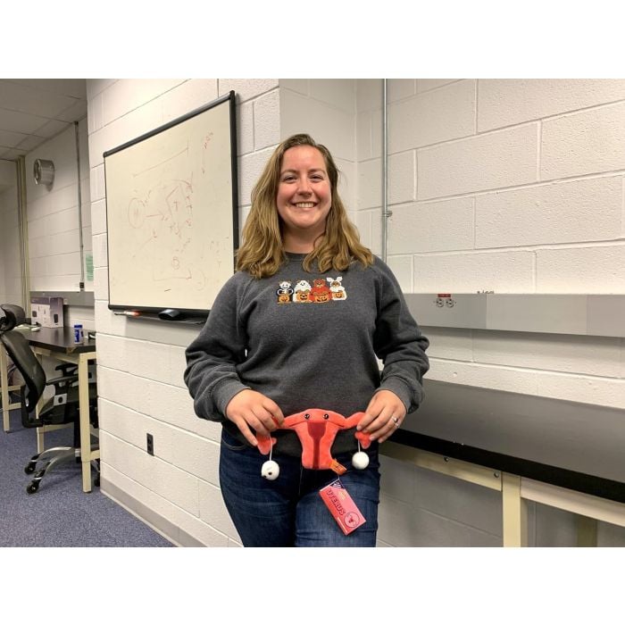 Model holding Uterus plush in class