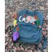 Fuzzy Fossils backpack on rocks